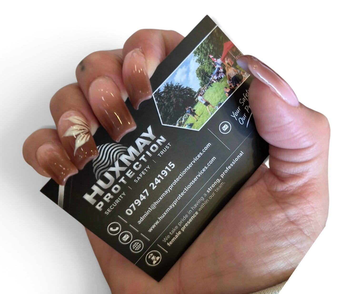 HuxMay Protection Services business card held in a hand